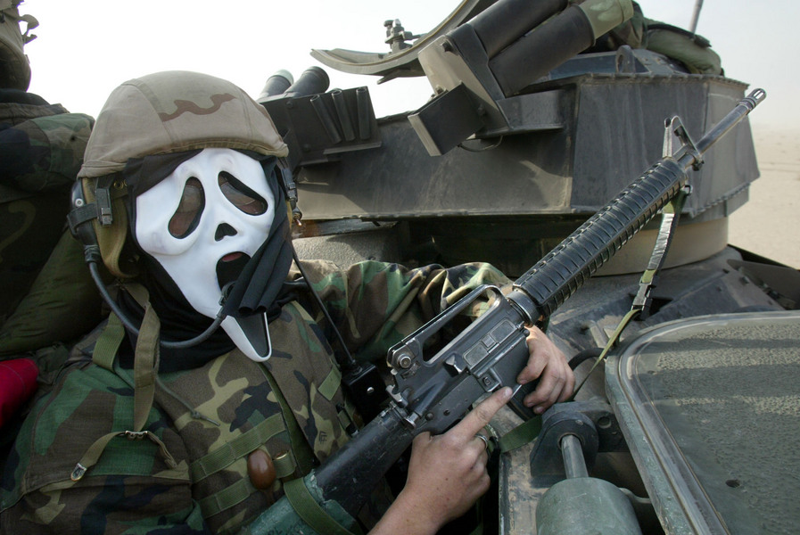 Cpl. Sterling wears a "Scream" mask as US Marines Regimental Combat Team 5, head north during the invasion of Iraq. © 2003 Mark Avery/Orange County Register