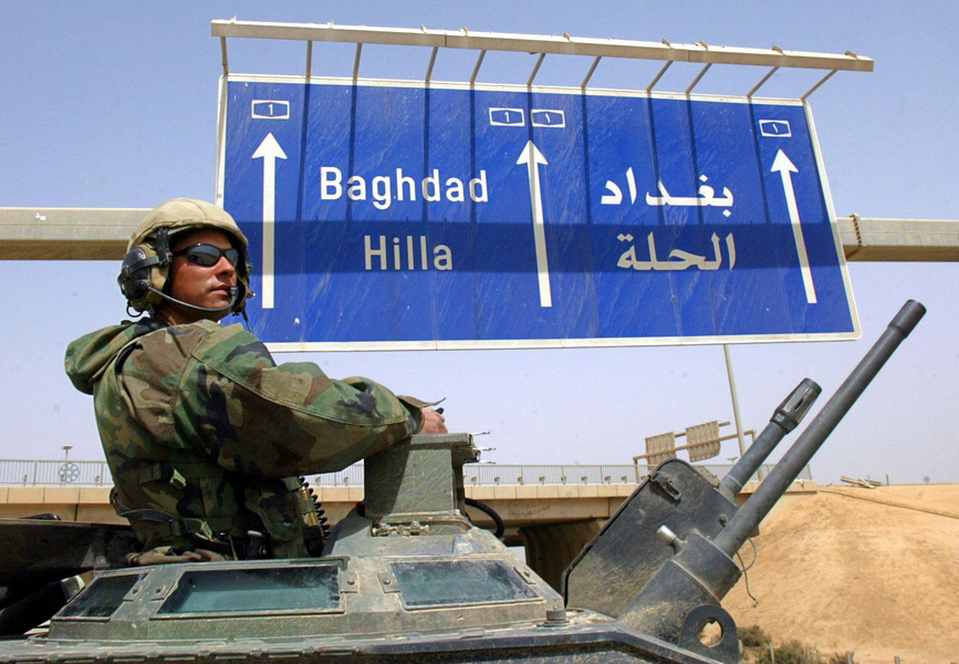Lt. Matt Fennell of Los Altos, CA, mans the turret of a US Marine AAV as Regimental Combat Team 5 heads north past an Iraqi traffic sign towards Baghdad. © 2003 Mark Avery/Orange County Register