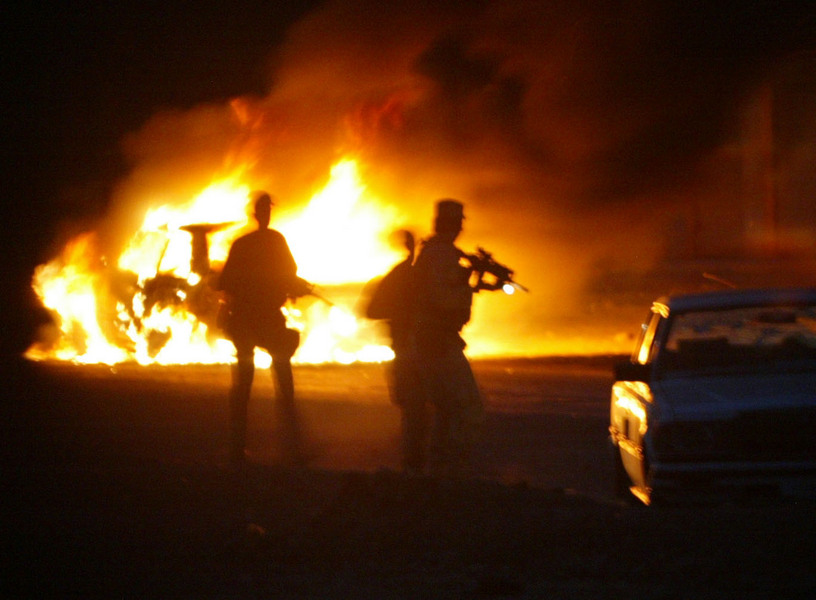 US Army Delta Force operatives approach to search a car after Iraqis got caught in the crossfire of a skirmish with US Marines on the outskirts of Baghdad. © 2003 Mark Avery/Orange County Register